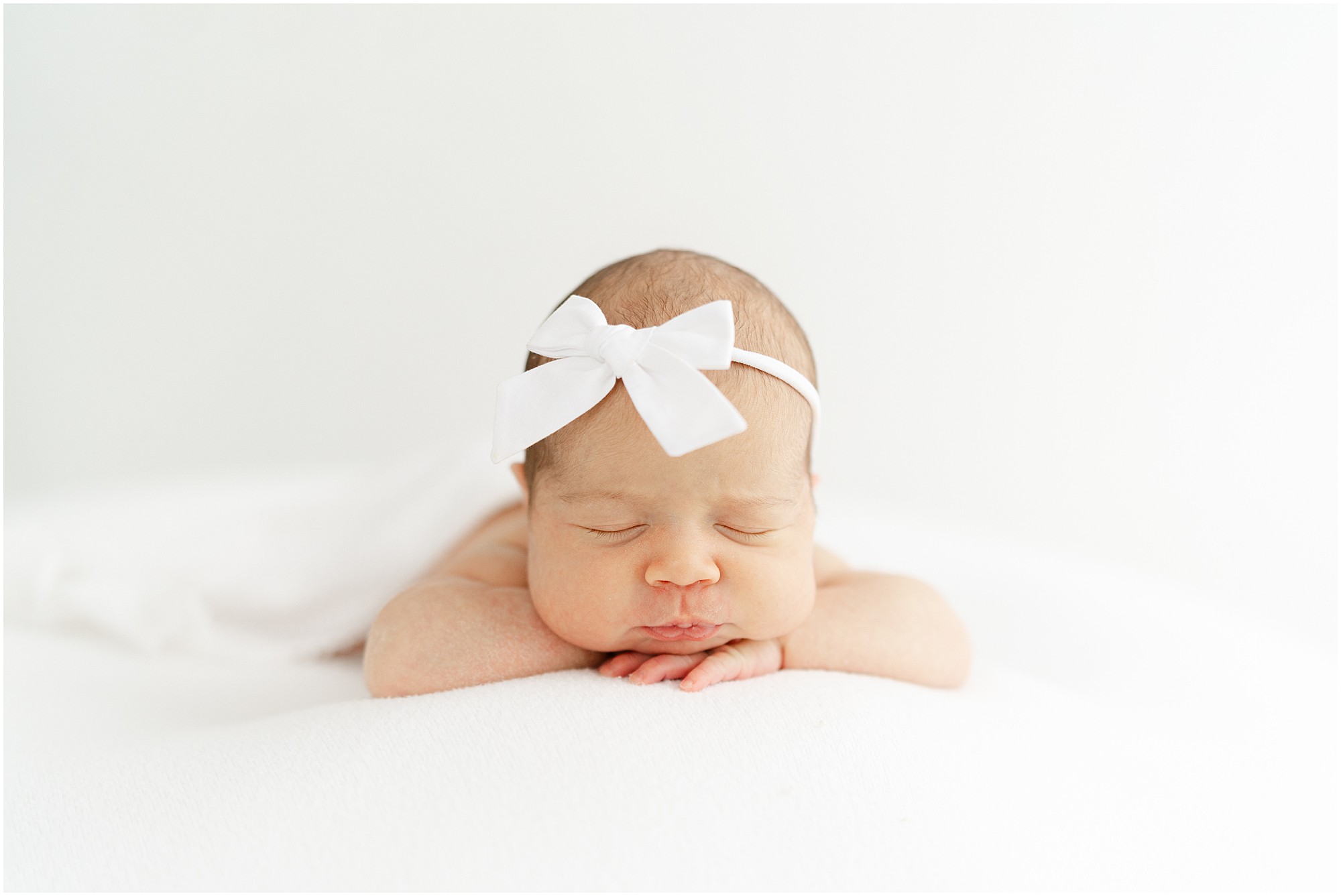 Atlanta studio newborn photography images of a newborn baby girl with a white headband.