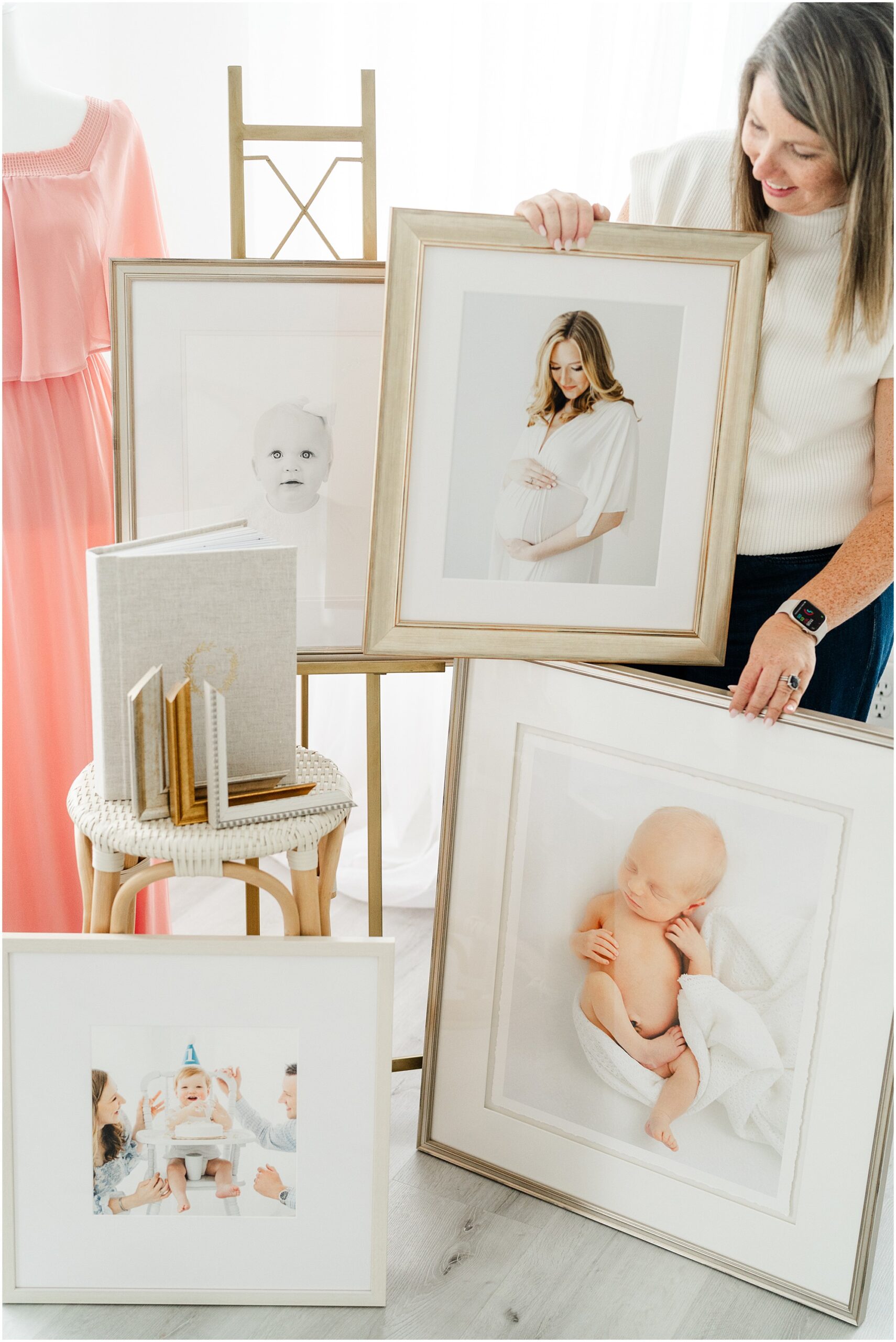 Atlanta photographer poses with custom framing of her client portraits.