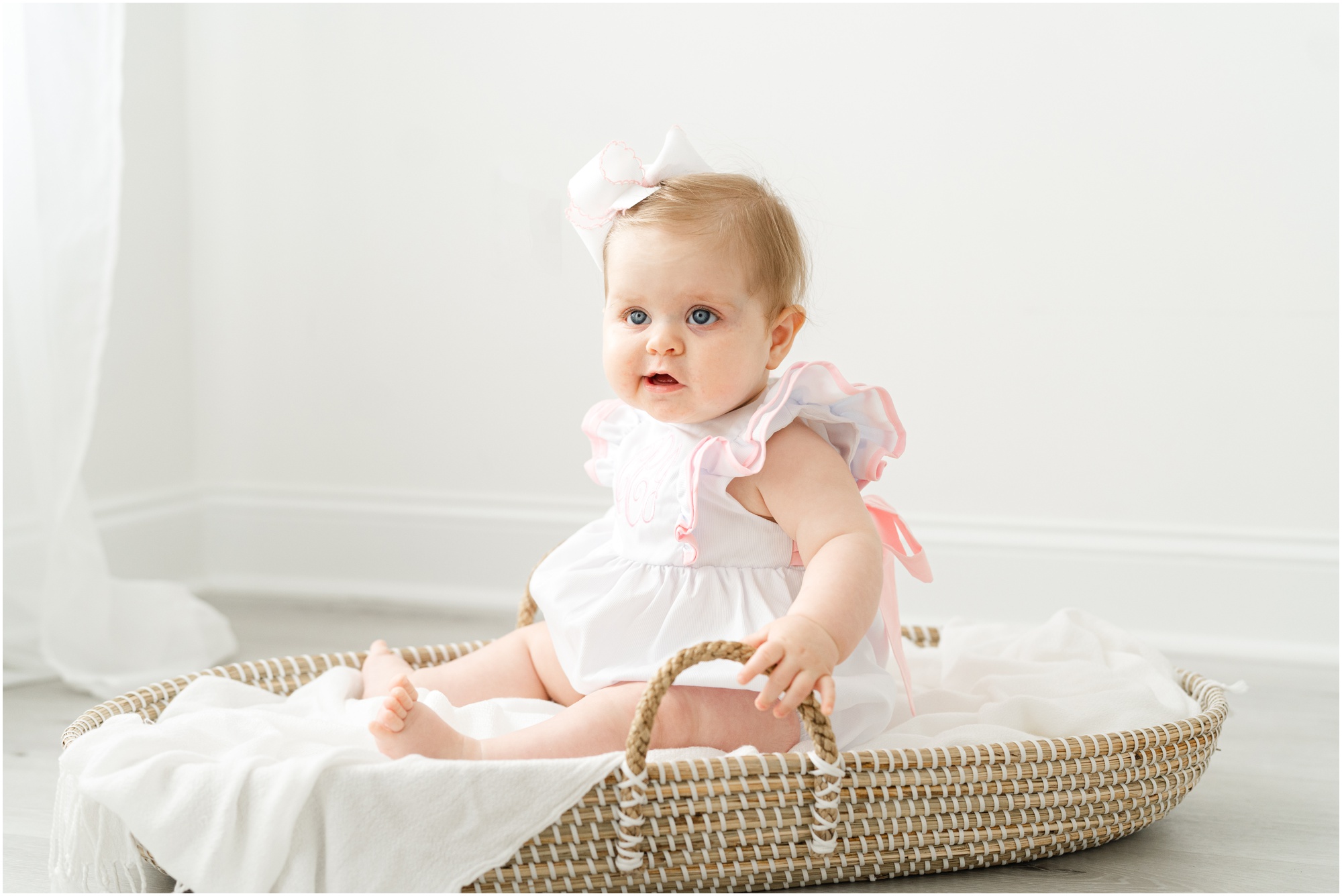 Portraits of a 6 month old baby with her toddler sister in an all white studio during an Atlanta sitter session.