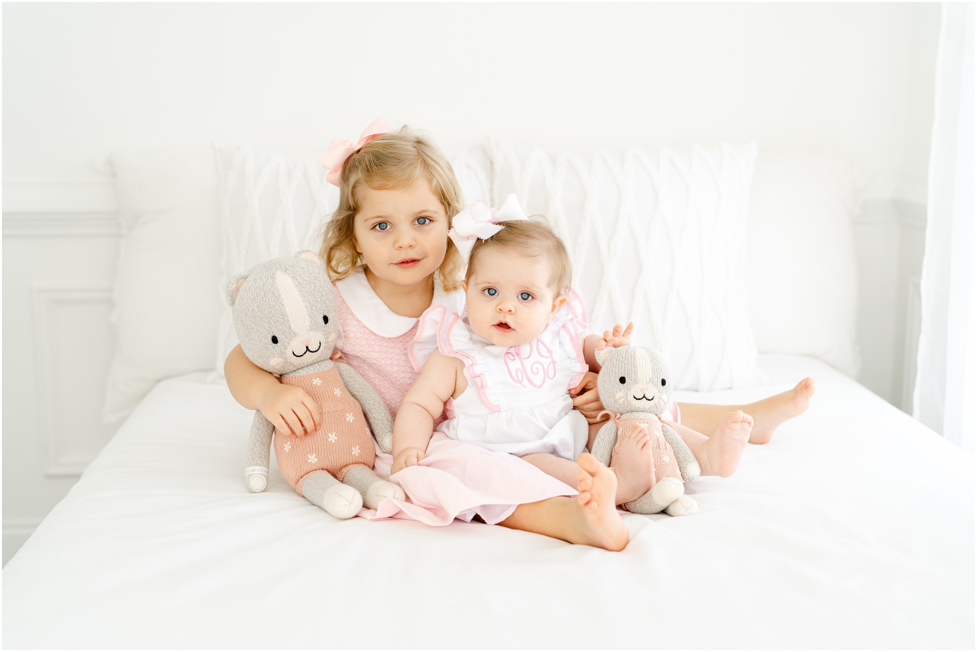 Portraits of a 6 month old baby with her toddler sister in an all white studio during an Atlanta sitter session.
